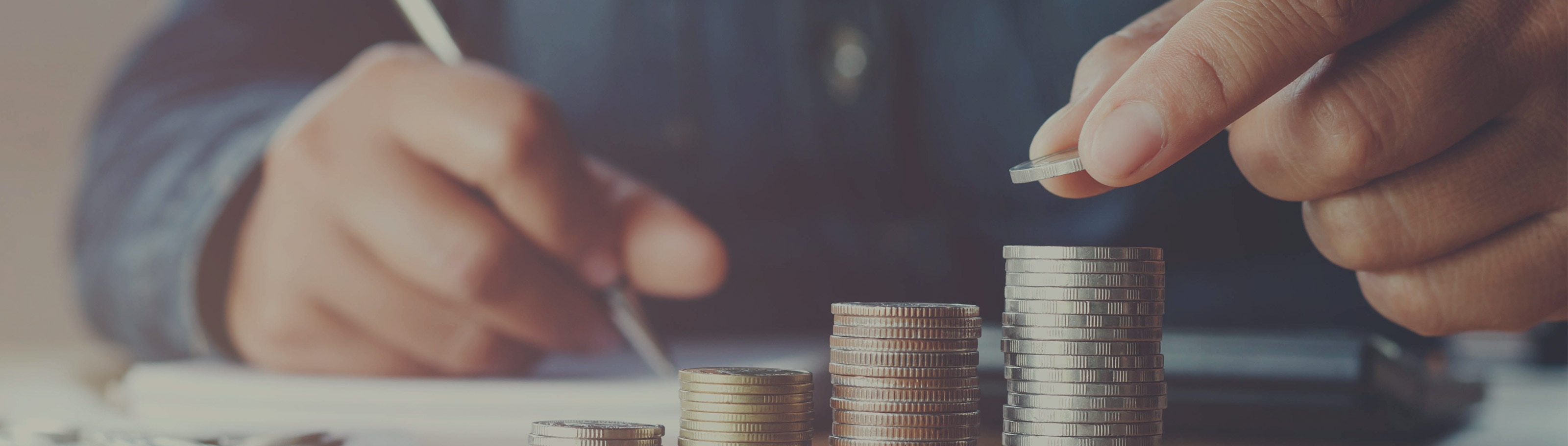 Haushaltsbuch zur Planung von Einnahmen und Ausgaben mit gestapelten Münzen