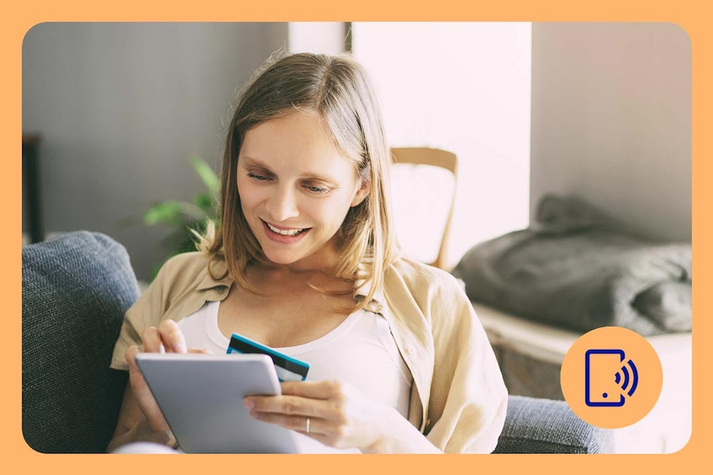 Person sitzt auf einem Sofa und verknüpft die BBVA Debitkarte mit PayPal auf einem Tablet