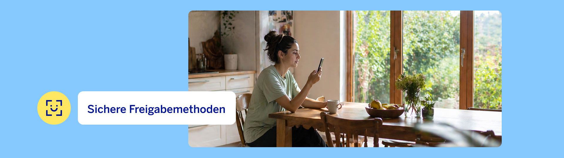 Eine Person sitzt am Esstisch der Küche und nutzt die Freigabemethoden von BBVA mit ihrem Smartphone.