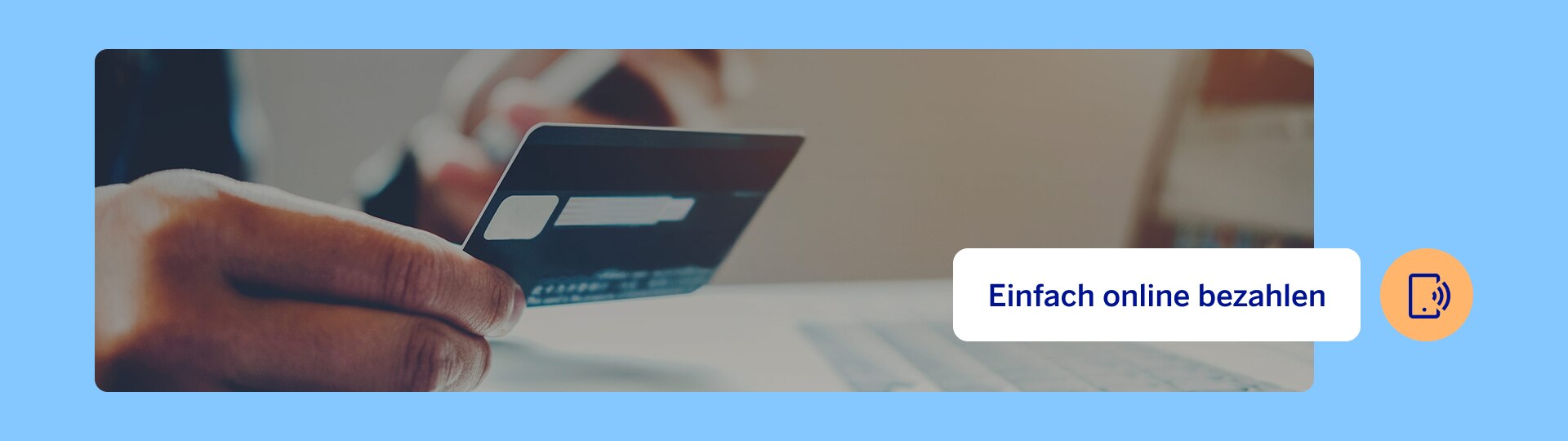 A hand is holding a debit card over a keyboard – a symbol for easy and secure online payment.