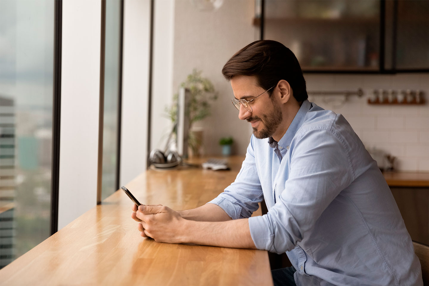 Person looking at their smartphone and reading information about BBVA Mediación.